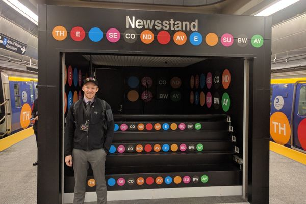 Erik standing in front of a decorated newstand at the open house for the Second Avenue Subway
